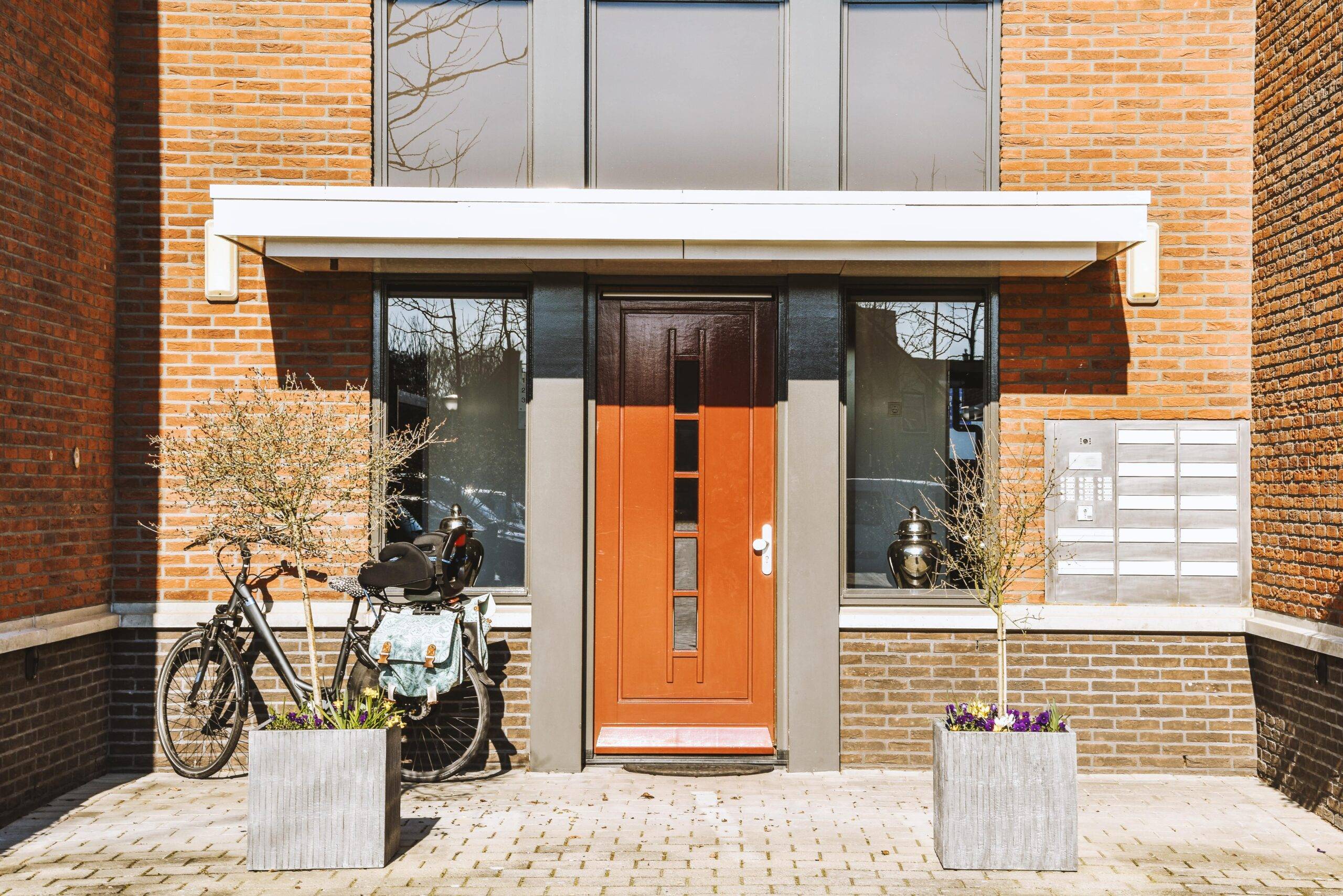 The front of a house with a terracotta door door.